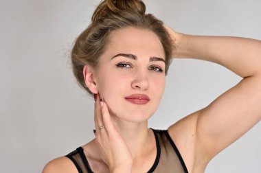 Beyaz arka planda kozmetik reklamcılığı için genel kadın portresi konsepti. Uzun saçlı ve mükemmel makyajlı güzel bir kızın büyük bir fotoğrafı farklı pozlarda duruyor..