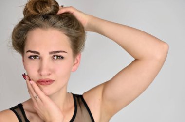 Beyaz arka planda kozmetik reklamcılığı için genel kadın portresi konsepti. Uzun saçlı ve mükemmel makyajlı güzel bir kızın büyük bir fotoğrafı farklı pozlarda duruyor..