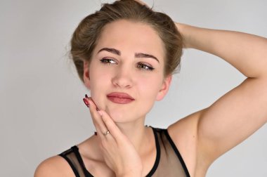 Beyaz arka planda kozmetik reklamcılığı için genel kadın portresi konsepti. Uzun saçlı ve mükemmel makyajlı güzel bir kızın büyük bir fotoğrafı farklı pozlarda duruyor..