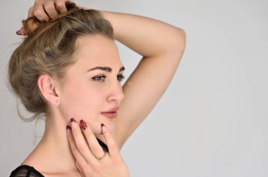 Beyaz arka planda kozmetik reklamcılığı için genel kadın portresi konsepti. Uzun saçlı ve mükemmel makyajlı güzel bir kızın büyük bir fotoğrafı farklı pozlarda duruyor..