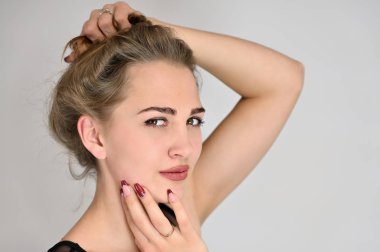 Beyaz arka planda kozmetik reklamcılığı için genel kadın portresi konsepti. Uzun saçlı ve mükemmel makyajlı güzel bir kızın büyük bir fotoğrafı farklı pozlarda duruyor..