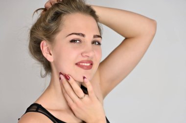 Beyaz arka planda kozmetik reklamcılığı için genel kadın portresi konsepti. Uzun saçlı ve mükemmel makyajlı güzel bir kızın büyük bir fotoğrafı farklı pozlarda duruyor..