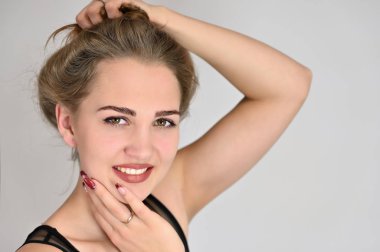 Beyaz arka planda kozmetik reklamcılığı için genel kadın portresi konsepti. Uzun saçlı ve mükemmel makyajlı güzel bir kızın büyük bir fotoğrafı farklı pozlarda duruyor..