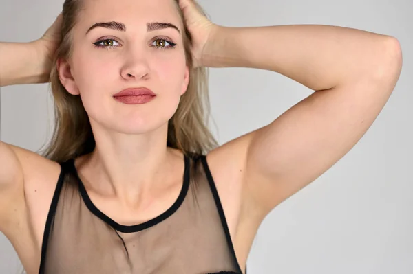 Generiek vrouwelijk portretconcept voor cosmetische reclame op een witte achtergrond. Een grote foto van een mooi lachend meisje met lang haar en uitstekende make-up staat in verschillende poses. — Stockfoto