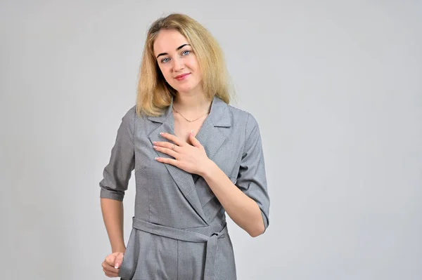 Portrait of a pretty cute smiling young blonde business woman with minimal makeup in a gray suit on a white background. Model Standing directly in front of the camera in various poses. — 스톡 사진