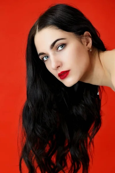 Uzun, güzel saç kavramı. Güzel esmer bir kızın yakın plan portresi mükemmel makyajlı ve lüks saçlı stüdyodaki kırmızı arka planda.. — Stok fotoğraf