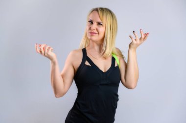 Beyaz arka planda eşofmanlı zayıf sarışın bir kadın sporcunun fotoğrafı. Etkili fitness konsepti. Duygular ve gülümsemeyle farklı pozlarda durmak.