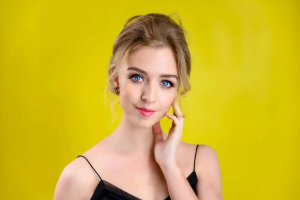 The concept of cosmetics, fashion and style. Glamorous beauty portrait of a pretty blonde model with excellent makeup and a beautiful hairstyle on a yellow background in the studio. — ストック写真