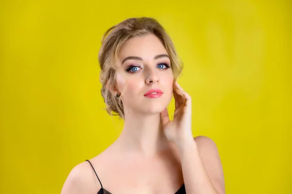 The concept of cosmetics, fashion and style. Glamorous beauty portrait of a pretty blonde model with excellent makeup and a beautiful hairstyle on a yellow background in the studio. — 스톡 사진