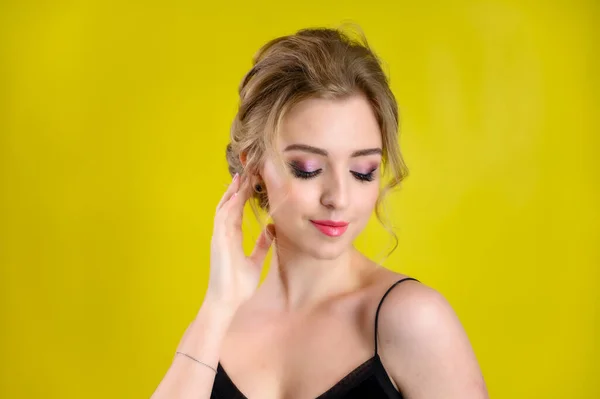 Glamoroso retrato de belleza de una bonita modelo rubia con excelente maquillaje y un hermoso peinado sobre un fondo amarillo en el estudio. El concepto de cosmética, moda y estilo . — Foto de Stock