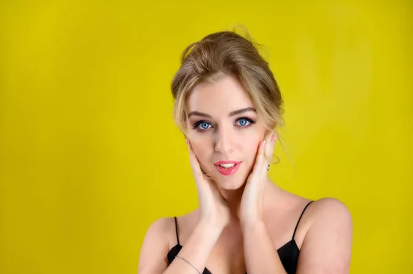 Glamorous beauty front view portrait of a pretty blonde model with excellent make-up and beautiful hairstyle on a yellow background in the studio. The concept of cosmetics, fashion and style. — 스톡 사진
