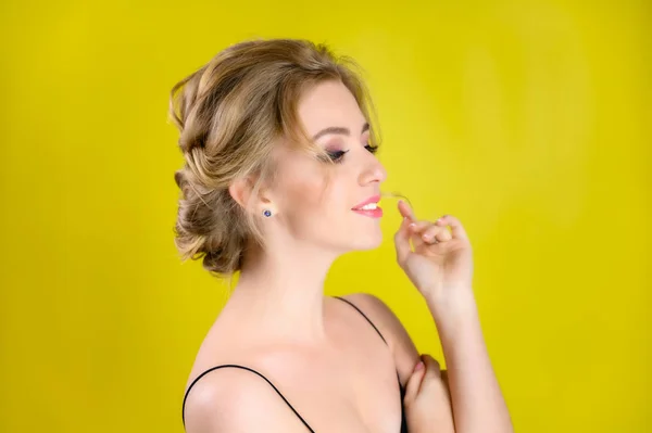 Glamouröse Schönheit Porträt Seitenansicht eines hübschen blonden Modells mit hervorragendem Make-up und einer schönen Frisur auf gelbem Hintergrund im Studio. Das Konzept von Kosmetik, Mode und Stil. — Stockfoto