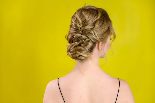 Glamorous beauty rear view portrait of a pretty blonde model with excellent make-up and beautiful hairstyle on a yellow background in the studio. The concept of cosmetics, fashion and style. — 스톡 사진