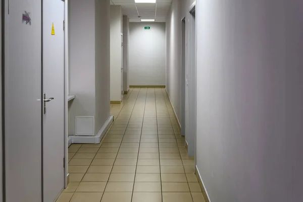 Zdjęcie korytarza w budynku z białymi ścianami i drzwiami do toalety — Zdjęcie stockowe