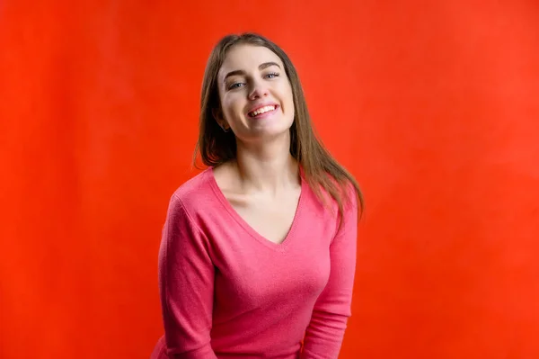 Foto Fundo Vermelho Uma Mulher Muito Sorridente Uma Camisola Rosa — Fotografia de Stock