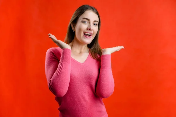 Foto Fundo Vermelho Uma Mulher Muito Sorridente Surpreso Uma Camisola — Fotografia de Stock