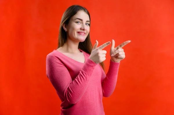 Retrato Fondo Rojo Una Joven Muy Sonriente Suéter Rosa Muestra — Foto de Stock