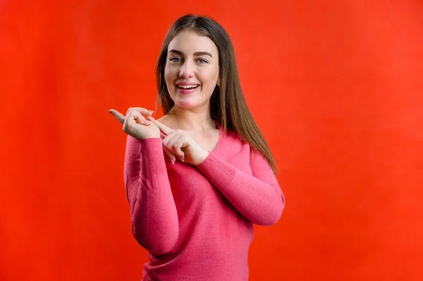 Portrait Red Background Pretty Smiling Young Woman Pink Sweater Shows — Stock Photo, Image