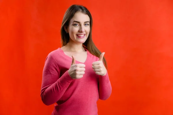 Portrait Red Background Pretty Smiling Young Woman Pink Sweater Shows — Stock Photo, Image