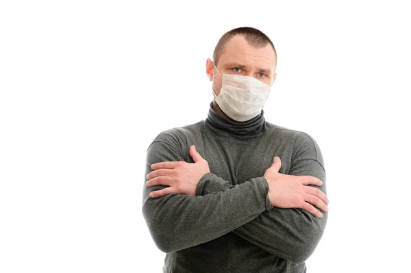 컨셉트 격리 심각 한 백인 남성의 흰색 배경에 회색 스웨터를 입고 의료용 마스크를 쓰고 두 손으로 감정을 표현 — 스톡 사진