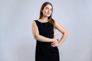 Beyaz arka planda iş portresi. Siyah elbiseli, gülümseyen, sempatik beyaz kadın.
