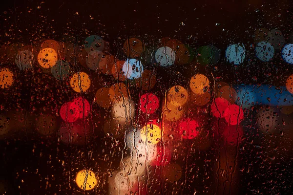 Photo of a night city from a window with beautiful colored lights with bokeh