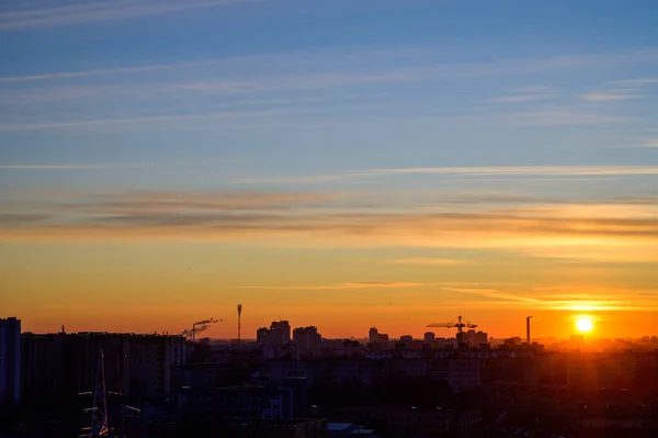 Photo of a morning sunrise in the sky above the city and houses on a clear spring morning