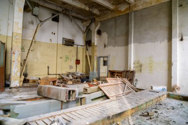 Kenar mahallelerdeki terk edilmiş bir fabrikanın içindeki çöplüğün fotoğrafı.