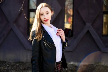 Güneşin altında duyguları olan gülümseyen güzel bir kızın bahar portresi. Kameranın önünde bir model duruyor..