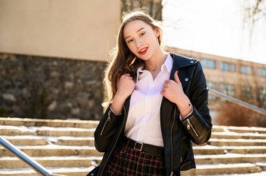 Güneşin altında duyguları olan gülümseyen güzel bir kızın bahar portresi. Model kameranın önünde mutluluğu gösterir