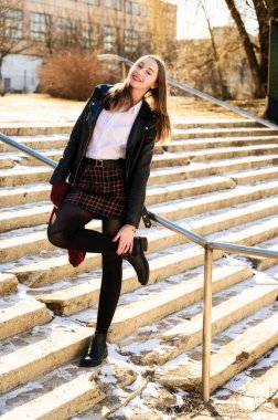 Açık havada duyguları olan gülümseyen güzel bir kızın tam boy bahar portresi. Model kameranın önünde mutluluğu gösterir