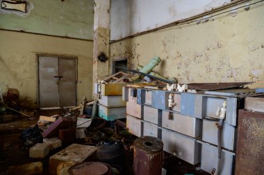 Yıkılmış bir fabrikanın terk edilmiş bir odasındaki çöplüğün fotoğrafı.