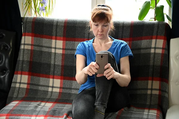 Fotografie Dospělé Ženy Modrém Tričku Karanténě Mluví Smartphonu Zatímco Sedí — Stock fotografie