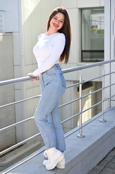 Foto Uma Menina Morena Caucasiana Uma Blusa Branca Jeans Azul — Fotografia de Stock
