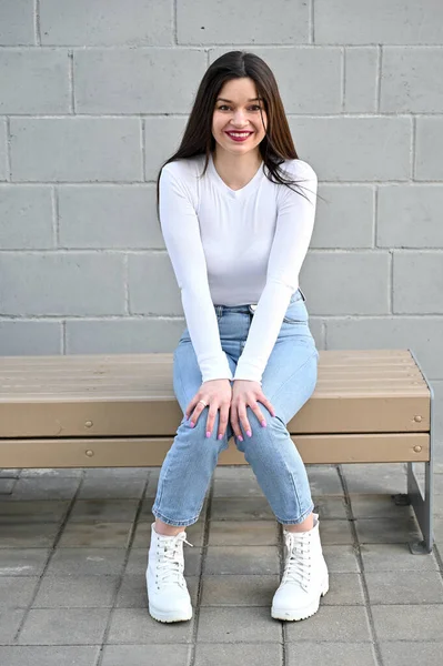 Retrato Caucásico Una Guapa Morena Blusa Blanca Jeans Azules Sentada — Foto de Stock