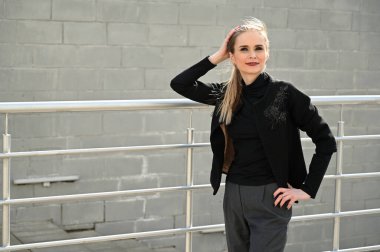 Güneşli bir günde, açık havada gülümseyen güzel beyaz bir kadının fotoğrafı. Gülümseyen ve zevk veren modaya uygun bir model..