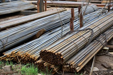 Açık havadaki palet yığınlarının fotoğrafı siyah metal yığını içinde yatıyor.