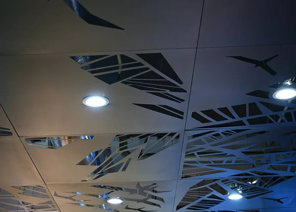 Photo of a gray ceiling with round lighting lamps in a shopping center