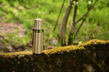 Yazın açık havada, ormanda bir termosun fotoğrafı. Turist tatili kavramı.
