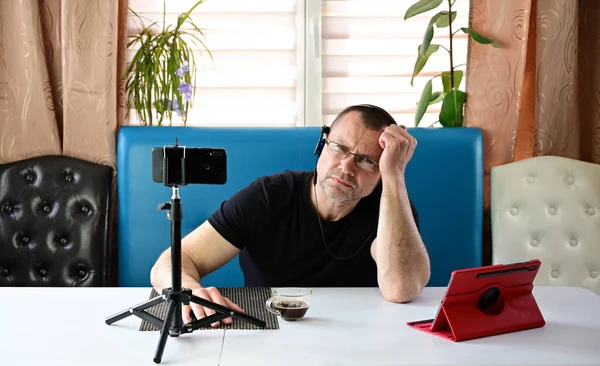 Retrato Homem Adulto Fones Ouvido Óculos Realiza Uma Videoconferência Smartphone — Fotografia de Stock