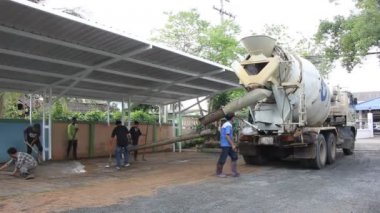 Bir grup inşaat işçileri büyük çimento kamyonu ile çalışmak.