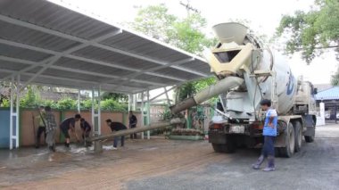 Bir grup inşaat işçileri büyük çimento kamyonu ile çalışmak.