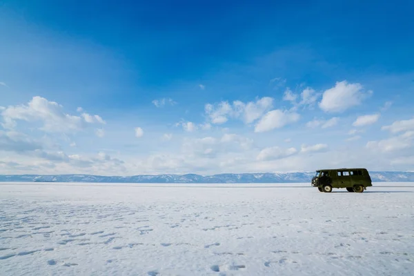 查看和通过冰在贝加尔湖结冰的领域与汽车 — 图库照片