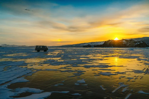 Minta jégen, a Bajkál-tó autóval naplemente alatt. Oroszország Siberia — Stock Fotó