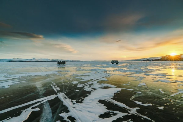 在日落时, 两辆汽车在贝加尔湖冰上的图案。西伯利亚俄国 — 图库照片