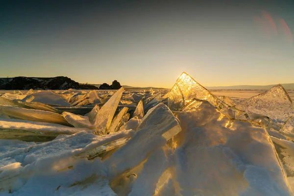 Vista su e attraverso il ghiaccio durante il tramonto sul lago Baikal. Russia, Siberia — Foto Stock