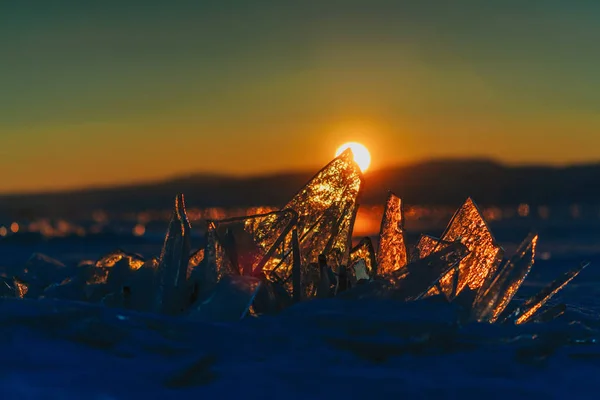 Vista su e attraverso il ghiaccio durante il tramonto sul lago Baikal. Russia, Siberia — Foto Stock