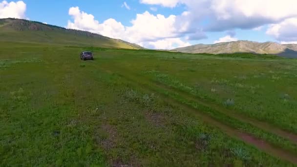 Widok z powietrza zielone łąki, wzgórza, w odległości i samochód terenowy w Republice Chakasji. Rosja — Wideo stockowe