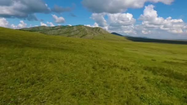 Aerial view of green meadows, hills in the distance and cloudy sky in the Republic of Khakassia. Russia — Stock Video