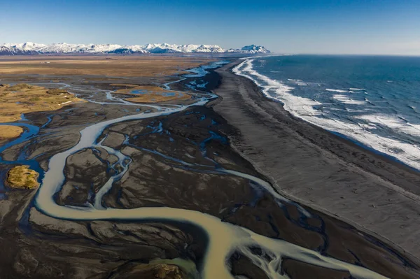 Vzdušný pohled na vzory islandských řek tekoucích do oceánu. Island na začátku jara — Stock fotografie